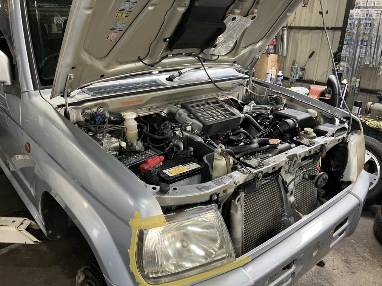 ボンネットを開けて整備をしようとしている車