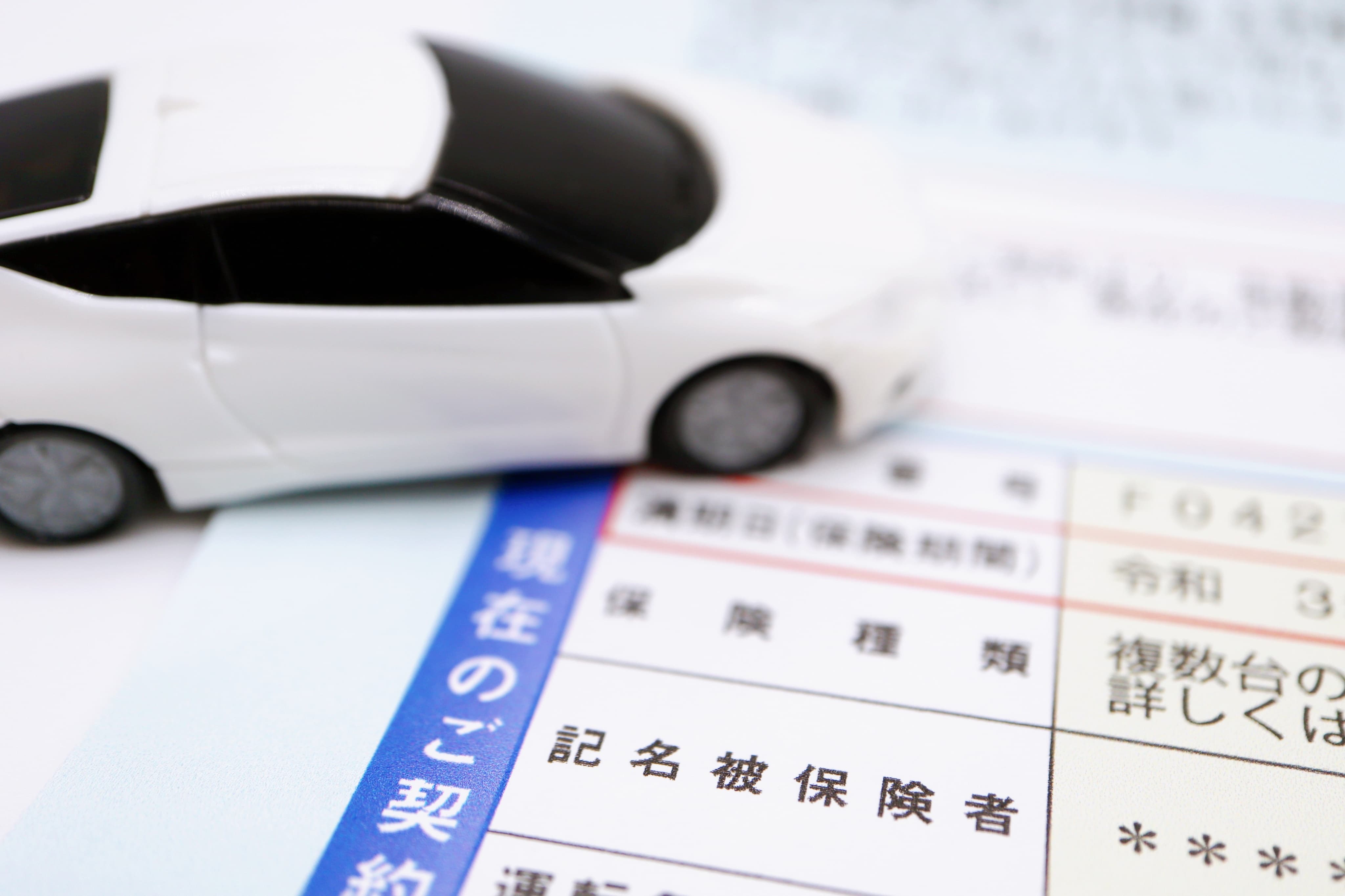 白いミニカーと保険の契約書